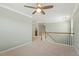 Upstairs landing features neutral carpet, ceiling fan, white trim, and staircase at 2128 Feather Ridge Dr, Holly Springs, NC 27540