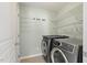 Laundry room with washer, dryer, and overhead storage; door to the left at 2128 Feather Ridge Dr, Holly Springs, NC 27540