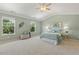 Spacious main bedroom featuring neutral carpet, ceiling fan, and multiple windows at 2128 Feather Ridge Dr, Holly Springs, NC 27540