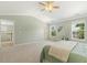 Main bedroom with neutral carpet, ceiling fan, and ample windows for natural light at 2128 Feather Ridge Dr, Holly Springs, NC 27540
