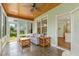 Inviting sunroom with comfortable seating, tile floor, and natural light, a perfect relaxation spot at 2128 Feather Ridge Dr, Holly Springs, NC 27540