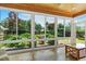 Bright sunroom featuring large windows offering serene views of the landscaped backyard at 2128 Feather Ridge Dr, Holly Springs, NC 27540
