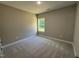 A secondary bedroom featuring carpet, neutral walls, and a window overlooking the backyard at 217 Busterfield Ct, Benson, NC 27504