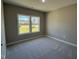 A secondary bedroom with neutral walls, carpet, and view of front yard through the double window at 217 Busterfield Ct, Benson, NC 27504