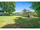 Large backyard featuring a firepit, a spacious lawn, and a covered lawn mower storage area at 2417 Ridgeford Ct, Fuquay Varina, NC 27526