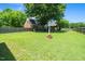 Expansive backyard with lush green grass, mature trees, and a charming brick home in a peaceful, fenced setting at 2417 Ridgeford Ct, Fuquay Varina, NC 27526