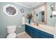 Bathroom featuring blue vanity, framed mirror, a stained glass window, and white walls at 2417 Ridgeford Ct, Fuquay Varina, NC 27526