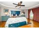 Bright main bedroom featuring a tray ceiling, hardwood floors, and blue accent furniture at 2417 Ridgeford Ct, Fuquay Varina, NC 27526