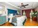 Bright main bedroom featuring a tray ceiling, hardwood floors, and blue accent furniture at 2417 Ridgeford Ct, Fuquay Varina, NC 27526