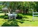 Relaxing backyard bench seating surrounded by mature trees, green grass and nice landscaping at 2417 Ridgeford Ct, Fuquay Varina, NC 27526