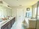 Bathroom featuring double vanity, separate tiled shower, soaking tub and tile floors at 2511 Kestrel Heights Ct Ct, Durham, NC 27703
