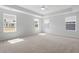 Spacious bedroom with tray ceiling, plush carpet, and generous natural light from large windows at 257 North Maple Walk Dr # 218, Garner, NC 27529