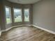 Bright bedroom featuring vinyl wood flooring, base molding, and large bright windows at 268 Busterfield Ct, Benson, NC 27504