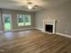 Living room featuring vinyl wood flooring, a fireplace, an exit door, and bright windows at 268 Busterfield Ct, Benson, NC 27504