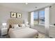 Bright bedroom with a tufted headboard bed, two bedside tables and large windows at 2700 Barrington Dr, Raleigh, NC 27610