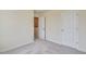 Neutral bedroom showcasing carpet, two white doors, and electrical outlets at 2700 Barrington Dr, Raleigh, NC 27610