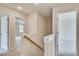 Bright hallway with carpeted floors, wooden handrail, and white doors providing access to other rooms at 2700 Barrington Dr, Raleigh, NC 27610
