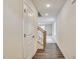 Long hallway with wood floors, leading to a staircase and a bright living area at 2700 Barrington Dr, Raleigh, NC 27610