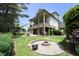 Expansive backyard featuring a fire pit, lush lawn, and covered patio, perfect for outdoor living at 2800 Charleston Oaks Dr, Raleigh, NC 27614