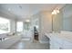 Spacious bathroom with soaking tub, tiled floors, double vanity, and natural light at 2800 Charleston Oaks Dr, Raleigh, NC 27614