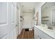 Clean bathroom with white vanity, shower/tub combo, and stylish wood-look flooring at 2800 Charleston Oaks Dr, Raleigh, NC 27614