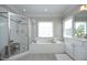 Bright primary bathroom featuring a soaking tub, separate shower and vanity at 2800 Charleston Oaks Dr, Raleigh, NC 27614
