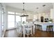 Open-concept kitchen boasts white cabinets, a large island with seating, and modern lighting fixtures at 2800 Charleston Oaks Dr, Raleigh, NC 27614