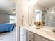 Stylish bathroom with double sinks, a large mirror, and a view into the main bedroom at 286 Beaver Tavern Dr, Benson, NC 27504