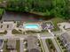 Aerial view of a neighborhood pool, clubhouse, parking lot, and bordering lake at 2915 Winter Crop Way, Apex, NC 27502