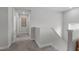 Upstairs hallway featuring neutral walls, carpet, white trim and railings, and artwork at 2915 Winter Crop Way, Apex, NC 27502