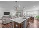 Open floor plan kitchen featuring large island with sink and dishwasher with great views of living and dining area at 2915 Winter Crop Way, Apex, NC 27502