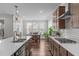 Kitchen with large island, stainless steel sink, and view into adjacent dining area with lots of natural light at 2915 Winter Crop Way, Apex, NC 27502
