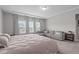 A bright main bedroom with carpet, tray ceilings, a seating area, and many windows at 2915 Winter Crop Way, Apex, NC 27502