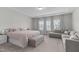 A stylish main bedroom with carpet, tray ceilings, a seating area, and several windows at 2915 Winter Crop Way, Apex, NC 27502