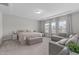 A bright main bedroom with carpet, seating area, and several windows at 2915 Winter Crop Way, Apex, NC 27502