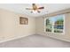 Neutral bedroom featuring a ceiling fan, carpet and large window allowing for natural light at 3027 Maple Ave # A-1, Burlington, NC 27215