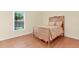 Bedroom featuring wood floors, a window for natural light and a wooden bed frame at 3027 Maple Ave # A-1, Burlington, NC 27215