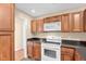 Cozy kitchen featuring dark countertops, wooden cabinets, and white appliances at 3027 Maple Ave # A-1, Burlington, NC 27215