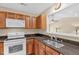 Kitchen featuring dark countertops, wooden cabinets, stainless steel sink, and white appliances at 3027 Maple Ave # A-1, Burlington, NC 27215