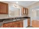 Kitchen featuring dark countertops, wooden cabinets, stainless steel sink, and white appliances at 3027 Maple Ave # A-1, Burlington, NC 27215