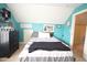 Upstairs bedroom featuring a sloped ceiling, teal walls, black furniture, and bright white trim for a modern retreat at 309 Forest Haven Drive Dr, Holly Springs, NC 27540
