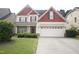 Traditional two-story home with a two-car garage, manicured lawn, and charming landscaping at 309 Forest Haven Drive Dr, Holly Springs, NC 27540