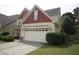 A spacious two-car garage of a charming home, complemented by lush landscaping and an inviting lawn at 309 Forest Haven Drive Dr, Holly Springs, NC 27540