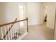 Upstairs hallway with wood and white banister and neutral carpet lead to various rooms, creating bright, open space at 309 Forest Haven Drive Dr, Holly Springs, NC 27540