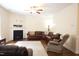 Spacious living room featuring a fireplace, ceiling fan, and comfortable seating arrangement at 309 Forest Haven Drive Dr, Holly Springs, NC 27540