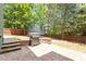 Backyard featuring a patio with stone steps and a built-in grill area, surrounded by mature trees at 309 Larkhaven Pl, Apex, NC 27539