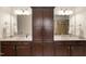 Bathroom vanity with dark cabinets, double sinks, and updated lighting fixtures, creating a spa-like atmosphere at 309 Larkhaven Pl, Apex, NC 27539