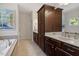 This bathroom features a double vanity, cabinets, a separate tub, and elegant decor at 309 Larkhaven Pl, Apex, NC 27539