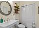Cozy bathroom with pedestal sink, round mirror and storage closet at 309 Larkhaven Pl, Apex, NC 27539