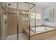 Bright bathroom showcasing a glass shower and tub, accented by decorative tiling and natural light at 309 Larkhaven Pl, Apex, NC 27539